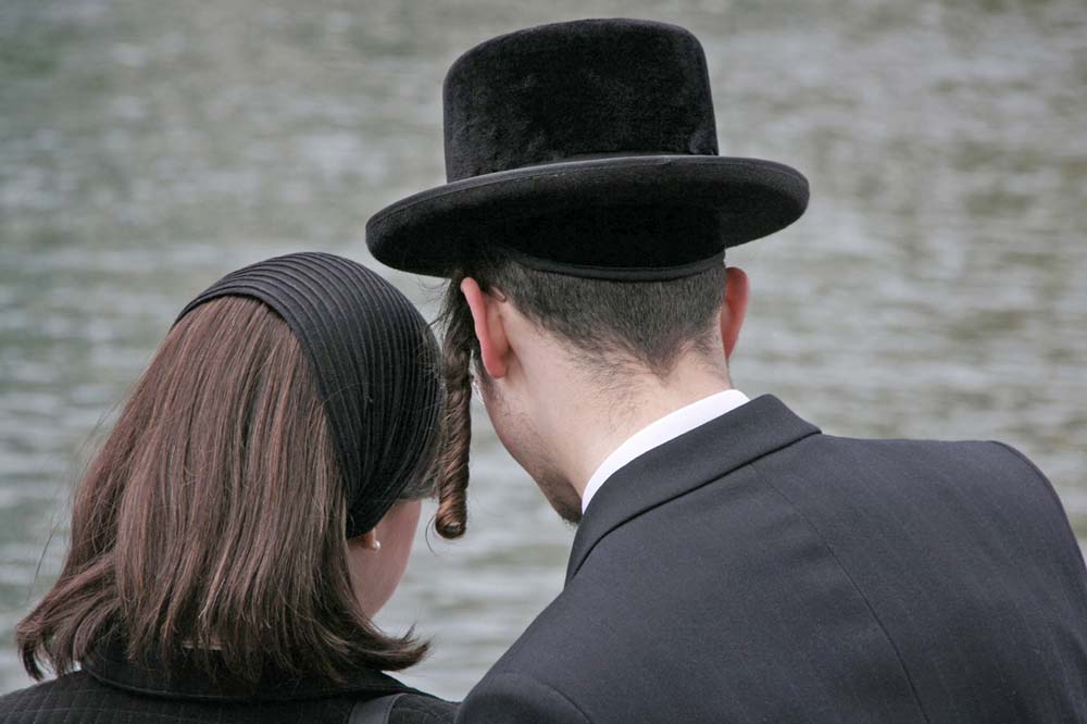 Hasidic man and woman shown from rear