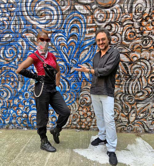 man and woman posing in front of mural wall