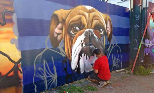 artist spray painting picture of dog