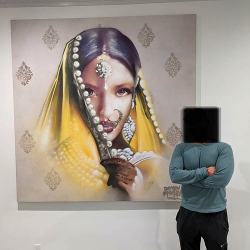 a man poses in front of a portrait artwork
