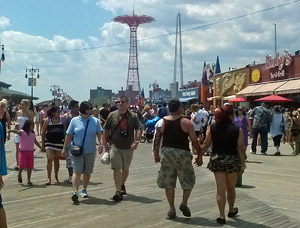 crowd walking on coney island boardwalk