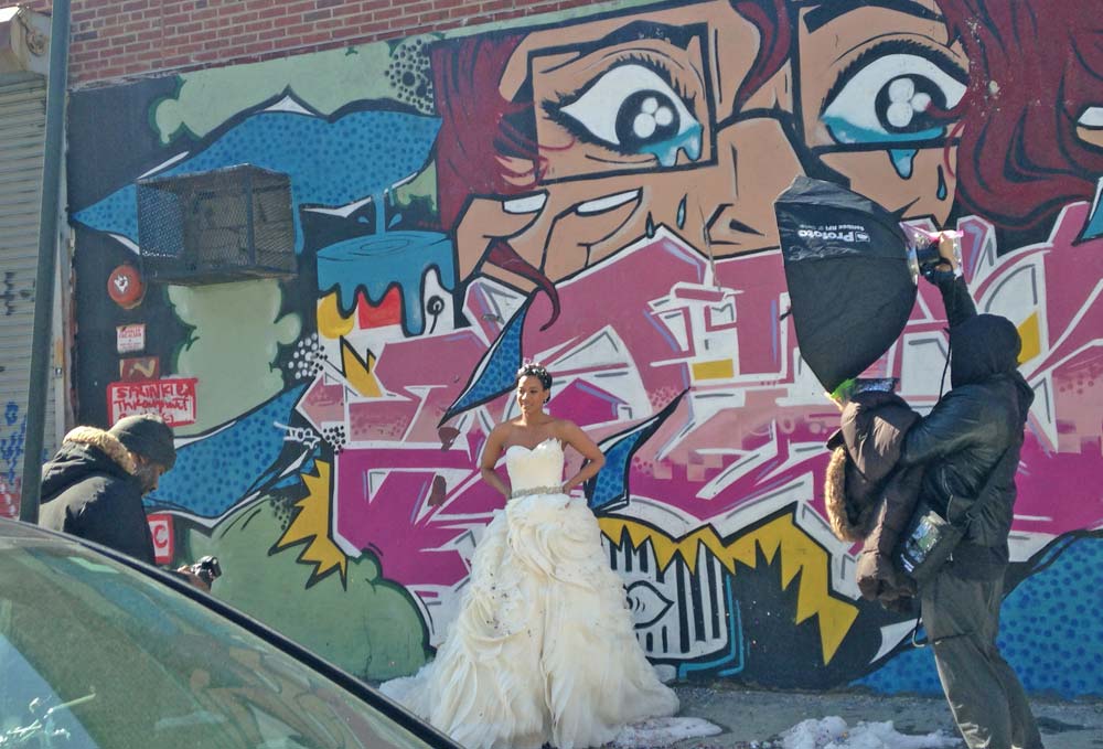 bride posing for photo shoot in front of graffiti wall