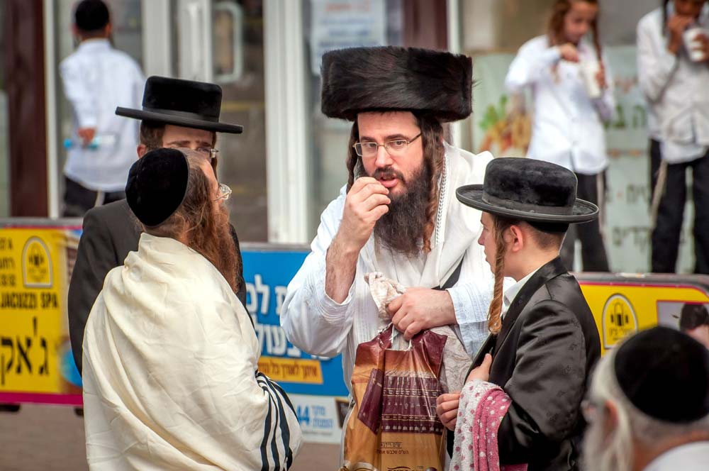 Hasidic Jewish men and boys talking in street